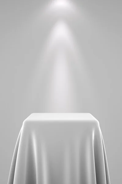 Pedestal com pano de seda branco e luz spot — Fotografia de Stock