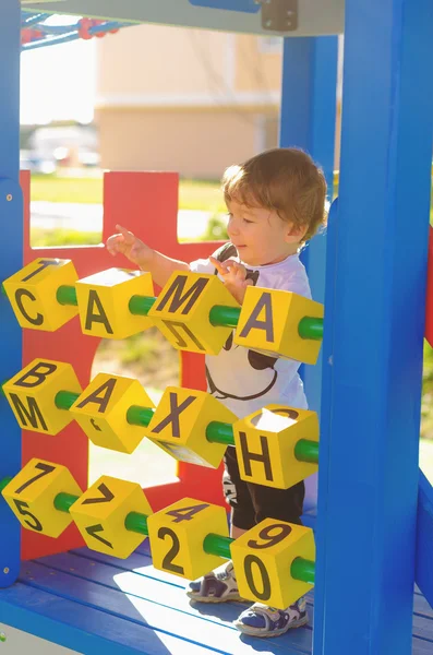Pequeño niño jugando en el patio con cubos . — Foto de Stock