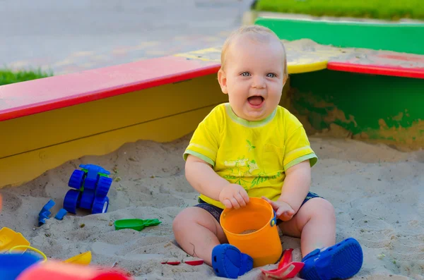 Niño jugando en una caja de arena — Foto de Stock