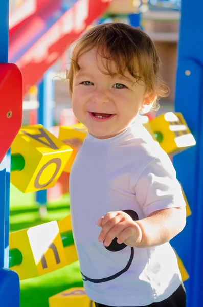 Pequeño niño jugando en el patio con cubos . — Foto de Stock