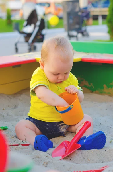 Niño jugando en una caja de arena — Foto de Stock