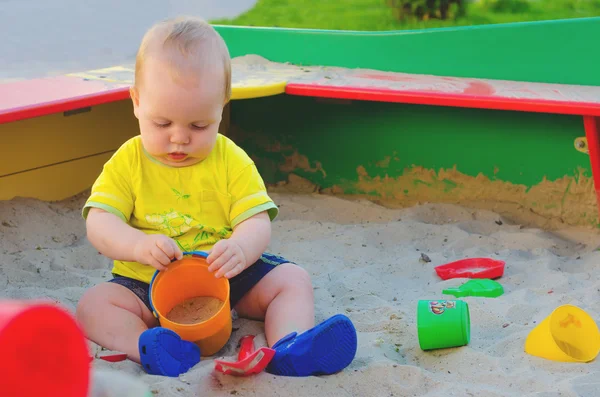 Niño jugando en una caja de arena — Foto de Stock