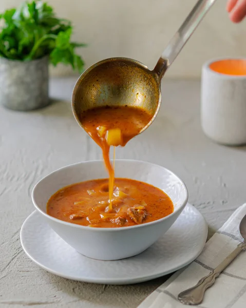 パプリカスープを食欲をそそる Bograch ハンガリー料理 スープはボウルに注ぎ込まれる 素朴な キッチン — ストック写真
