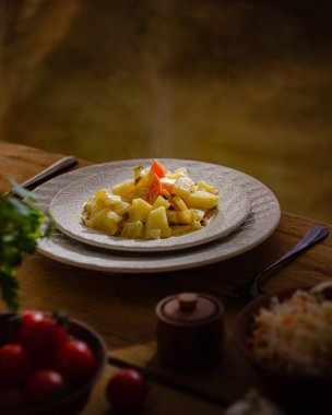 Tahta bir masada havuçlu haşlanmış patates tabağı. Köylü tarzı, basit hafif yiyecekler..