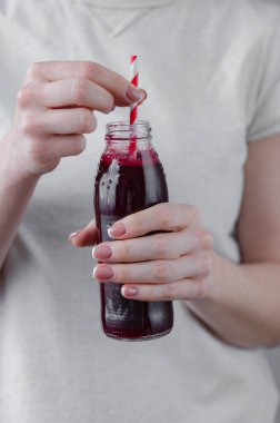 Kadın şişeden taze pancar suyu içiyor. Sebze suyu. Pipetle bir içki iç. Sağlık hizmetleri