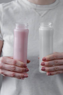 Kadın elinde protein kokteyli (süt ve kakao) olan iki cam şişe tutuyor. Pipetle bir içki iç. Sağlık hizmetleri