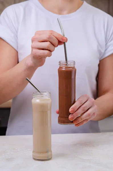 Kadın Elinde Protein Kokteyli Süt Kakao Olan Iki Cam Şişe — Stok fotoğraf
