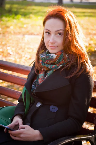 Nice woman in a park in autumn — Stock Photo, Image