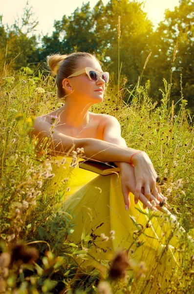 Belle femme allongée sur l'herbe et lisant un livre — Photo