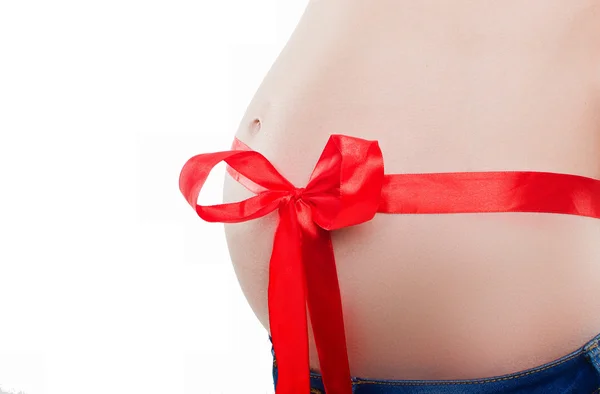 Belly of pregnant woman tied satin ribbon — Stock Photo, Image