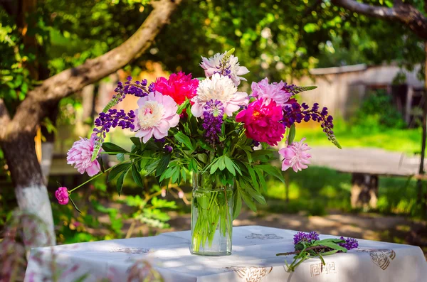 Hermoso ramo de peonías y altramuz sobre la mesa en el gree — Foto de Stock