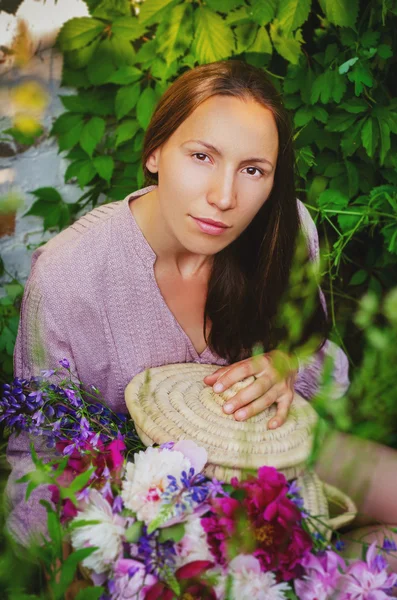 Femme tendre reposant dans des fourrés herbeux avec un beau bouquet — Photo