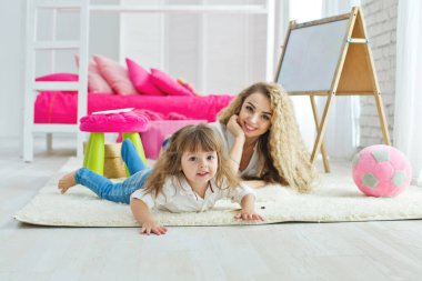 Sevgi dolu bir aile. Anne ve kızı çocuk odasındalar. Komik anne ve güzel bebek içeride eğleniyor. Sevimli küçük kız bir kadınla oynuyor.. 