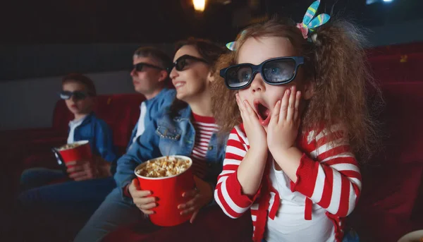 Family mom father and children are watching a projector, TV, cinema, movies with popcorn in the cinema. — Stock Photo, Image