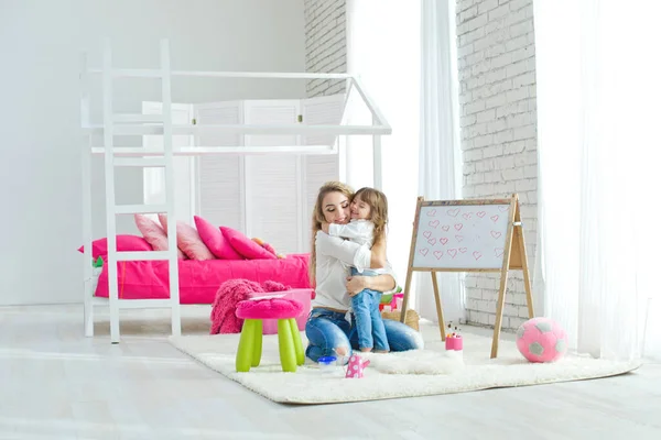 Happy loving family. Mother and daughter in the childrens room. Funny mom and lovely baby having fun indoors. Cute little girl is playing with a woman. — Stock Photo, Image