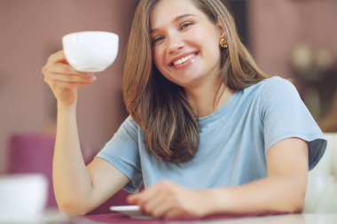 Kafeteryada elinde kahve fincanıyla oturan düşünceli olgun bir kadın. Orta yaşlı bir kadın düşünürken çay içer. Kahve içerken rahatlamak ve düşünmek..