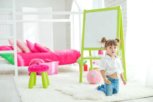 Мила маленька дівчинка на килимі вдома. Весела мила дитина розважається в розпліднику . — стокове фото