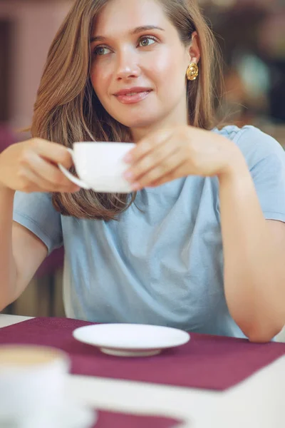 Удумлива зріла жінка сидить в кафетерії, тримаючи кавовий кухоль. Жінка середнього віку п'є чай під час роздумів. Розслабляючись і думаючи під час пиття кави . — стокове фото