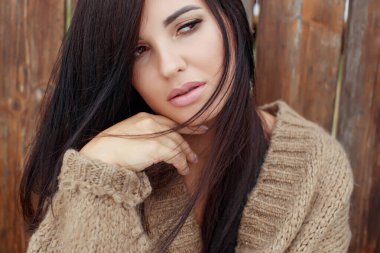 Açık havada gülümseyen genç bir kadın portresi. Yumuşak güneşli renkler. Portreyi kapat.