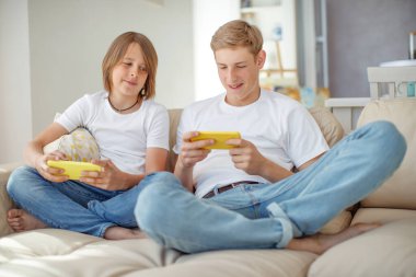 eğlence, teknoloji, aile ve insan konsepti - akıllı telefonları olan mutlu çocuklar ve çocuklar mesaj yolluyor ya da evde oyun oynuyorlar