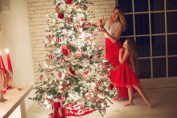 メリークリスマスとハッピーホリデー。夜に屋内にクリスマスツリーを持つ母と娘。クリスマスの前の晩。近くの愛する家族の肖像画. — ストック写真