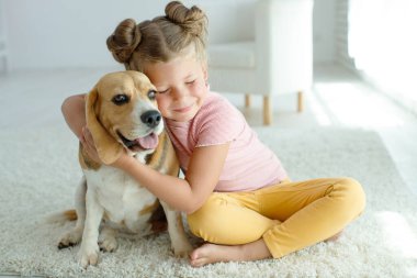 Köpeği olan mutlu bir çocuk. Evcil hayvanlı bir kızın portresi. Beagle bir genci yalıyor..