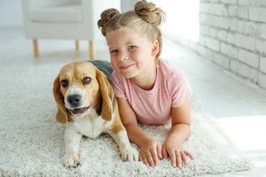 Köpeği olan mutlu bir çocuk. Evcil hayvanlı bir kızın portresi. Beagle bir genci yalıyor..