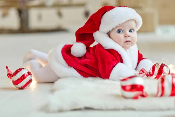 A beautiful little child is celebrating Christmas. New Years Holidays. Child in a Christmas costume with a gift. — Stock Photo, Image