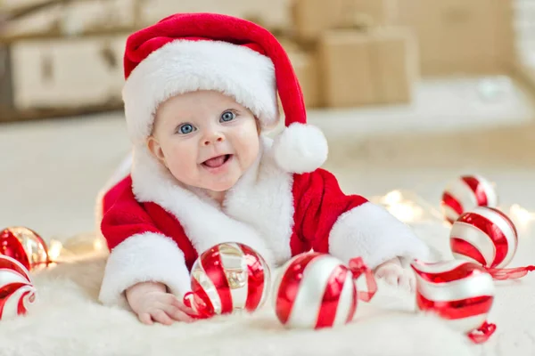 Uma criança linda está comemorando o Natal. Férias de Ano Novo. Criança em um traje de Natal com um presente. — Fotografia de Stock