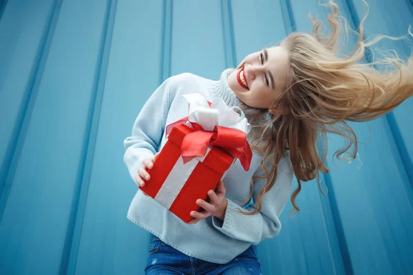 Gyönyörű, elegáns, fiatal szőke nő egy ajándékdobozzal a kezében. Karácsonyi fotók, ajándékok. — Stock Fotó