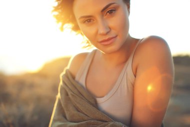 Güzel bir kızın portresi yakın plan, dalgalı saçlar. Açık havada gülümseyen genç kadın portresi..