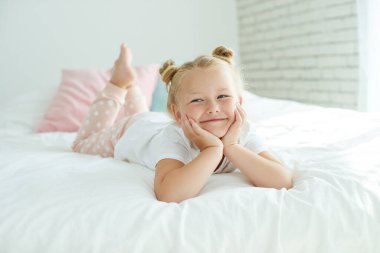 Güzel bir kız bebek güneşli bir sabahın tadını çıkarıyor. Evde günaydın. Kız uykudan uyanır..