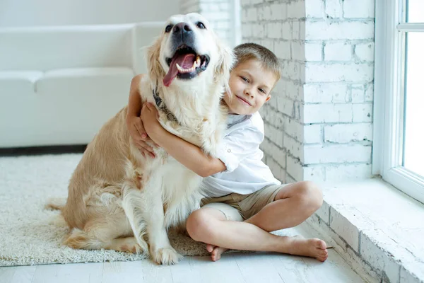 Little boy with a dog at home on the carpet. Friendship, care, happiness, new concept of the year. — Stock Photo, Image