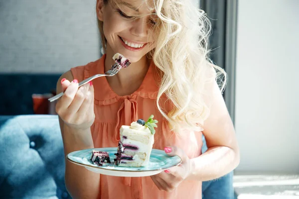 Щаслива мила молода жінка їсть солодкий смачний десерт у відкритому кафе. Смачна їжа, концепція життя . — стокове фото