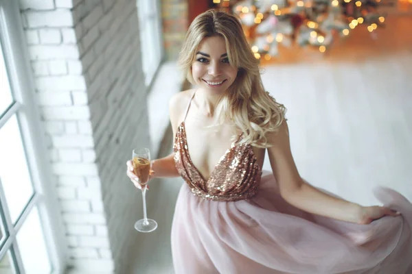 Impreza, drinki, wakacje, ludzie i koncepcja uroczystości - uśmiechnięta kobieta w pięknej sukience ze szklanką musującego wina i szampana na tle choinki. — Zdjęcie stockowe