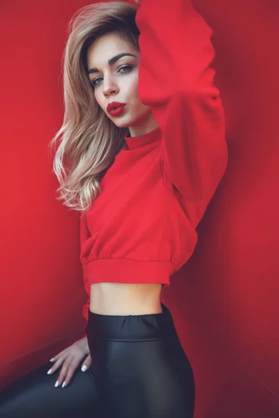 Ritratto di moda di una bella donna in stile su sfondo rosso. — Foto Stock