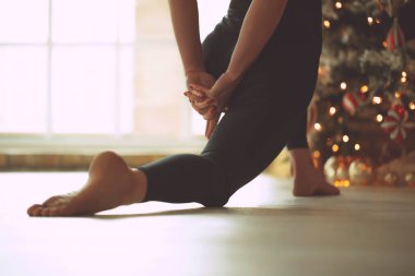 Genç bir kadın Noel 'de yoga dersinde meditasyon yapıyor. Özgürlük kavramı. Sakinlik ve rahatlama, kadın mutluluğu. Renkli çizim.