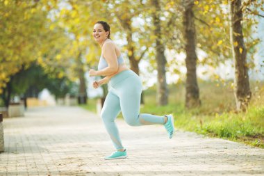 Şişman kadın koşuyor, kilo vermek için spor yapıyor, obezite problemi var..