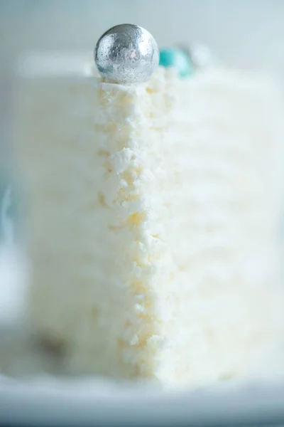 クリームとホワイトチョコレートを飾るバニラスポンジケーキ。白いプレートの上にケーキのスライス作品。お祝い事や誕生日パーティーのための好きなデザート. — ストック写真
