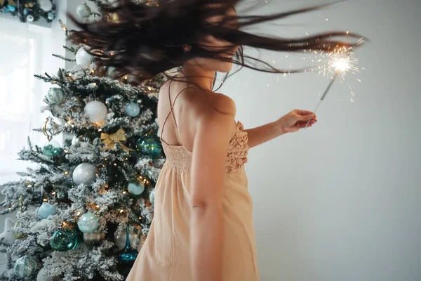 A woman with a sparkler at Christmas. — Stock Photo, Image