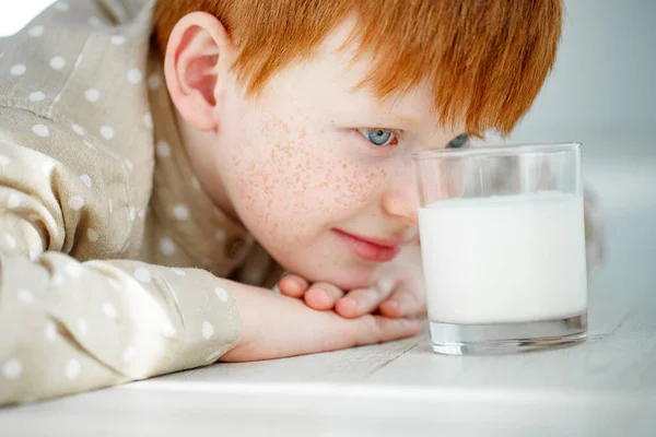 Il bambino sta facendo colazione. Il bambino beve latte e mangia biscotti. I bambini mangiano in una mattina di sole. Nutrizione sana ed equilibrata per i bambini. — Foto Stock