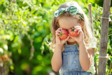Çocuk ve sebze. Seçici odaklanma. Doğru yiyecekle doğadaki küçük kız.