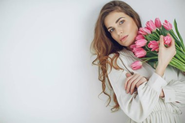 Güzel genç bir kadın laleleri tek başına tutuyor. Kameraya bakıyorum..