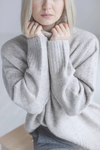 Bella giovane donna, maglione caldo su uno sfondo chiaro, foto dettagliata. — Foto Stock