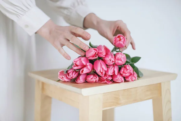 Жіночі руки з тюльпанами, флорист робить букет . — стокове фото