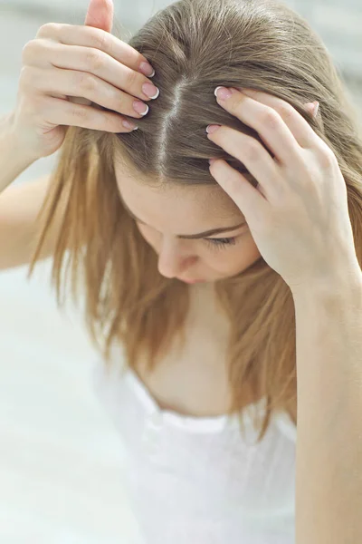 Young woman with hair loss problem on white background, closeup. Woman hair problem.