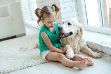 Köpeği olan mutlu bir çocuk. Evcil hayvanlı bir kızın portresi. Labrador Retriever evde. 