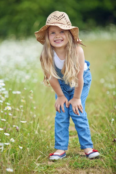 Little girl in a field of flowers. The child has fun in nature. — Stock Photo, Image