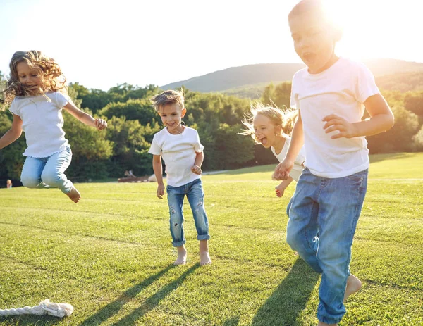 Dört çocuk yeşil çimenlerde oturur ve donut yer ve gülümser, tatlı yemek, iyi bir arkadaşlık..