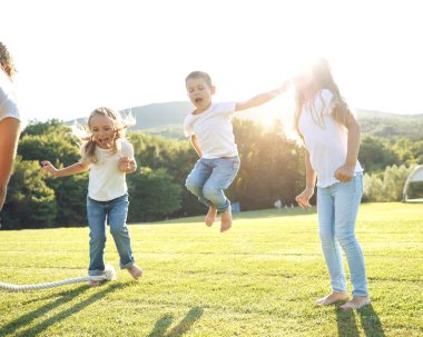 Dört çocuk yeşil çimenlerde oturur ve donut yer ve gülümser, tatlı yemek, iyi bir arkadaşlık..